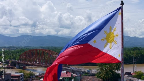 Philippine flag flying above Butuan City Caraga Mindanao with Magsaysay Bridge and Agusan River in the Background.