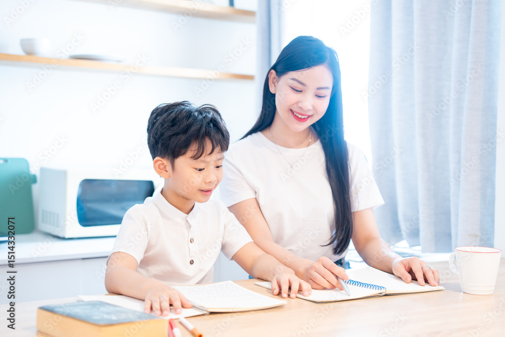 A young student receives assistance from an adult while working on schoolwork in a bright kitchen A young student receives assistance from an adult while working on schoolwork in a bright kitchen