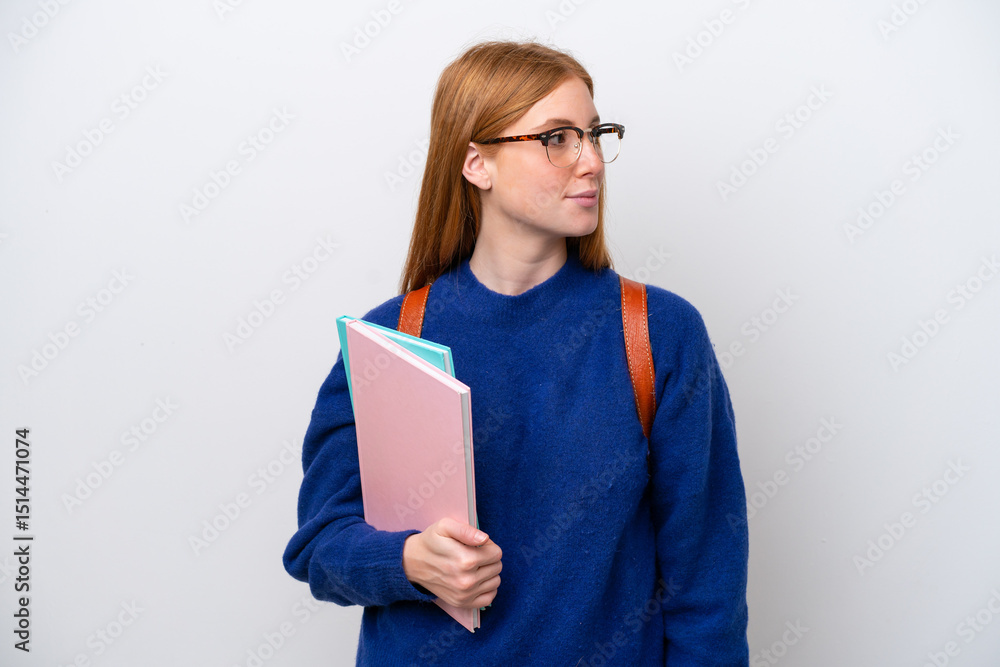 Young student redhead woman isolated on white background looking to the side Young student redhead woman isolated on white background looking to the side