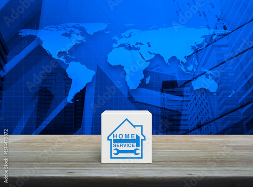 Fototapeta Naklejka Na Ścianę i Meble -  Hammer and wrench with house icon on white block cube on wooden table over world map, city tower and skyscraper, Business home service concept, Elements of this image furnished by NASA
