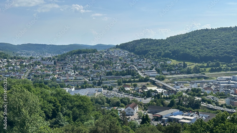 Obraz premium Panoramic view of the charming town of Herborn, Germany, captured from the top of the Aussichtsturm Dillblick observation tower. The image reveals a picturesque blend of historic rooftops, green hills