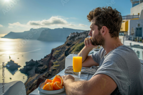 Wallpaper Mural Man enjoying breakfast with orange juice on a terrace overlooking the stunning views of a coastal town. Torontodigital.ca
