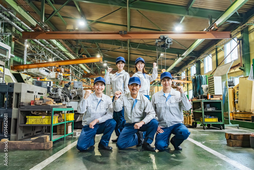 Foto 工場の中でガッツポーズする作業員グループ