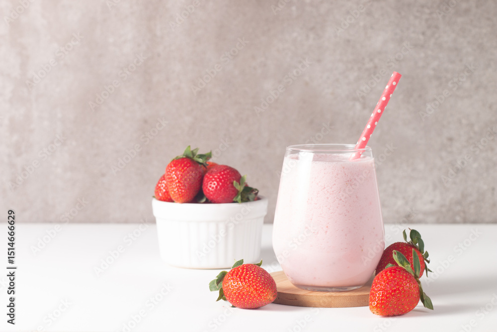 Glass of fresh strawberry milkshake, smoothie and fresh strawberries on white and wooden background. Healthy food and drink concept. Glass of fresh strawberry milkshake, smoothie and fresh strawberries on white and wooden background. Healthy food and drink concept.