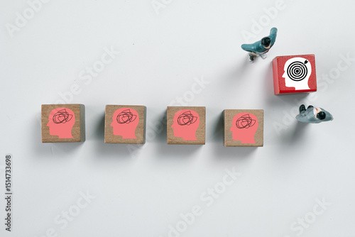Fotografi Businessman focus on red wooden with dartboard icon among Wooden blocks with confused head icons Concept of business strategy, achieving targets,Goal setting and achievement for success