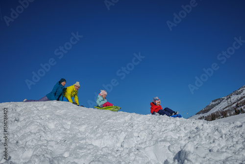 Foto Family enjoys a sunny day sledding on snowy hills