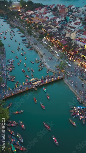 Wallpaper Mural Timelapse, speed montion. Drone view of Hoi An Ancient Town at sunset or twilight, bustling with tourists, colorful lanterns, and boats on the river. Perfect for travel, tourism, and cultural visuals Torontodigital.ca