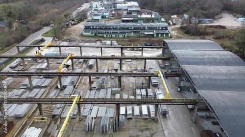Wide Overhead View of Industrial Storage and Production Yard with Gantry Cranes and Steel Materials