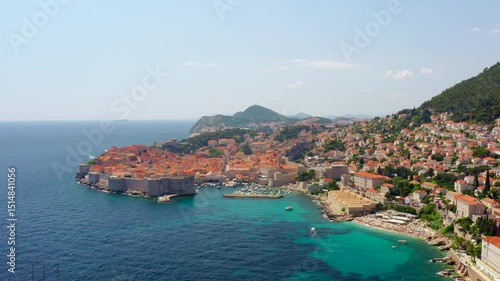 Establishing aerial panorama of Dubrovnik, Croatia. Famous historic old town, and picturesque coastline with boats. Majestic landscape of Adriatic Sea and European architecture. 4K wide drone shot