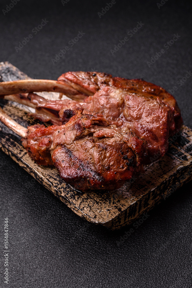 Obraz premium Juicy meat on the bone or rack of lamb. Grilled veal with salt, spices and herbs
