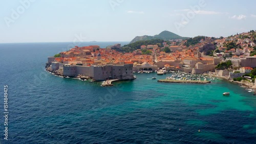 Establishing aerial footage of Dubrovnik, Croatia. Famous historic old town, and picturesque coastline with boats. Majestic panorama of Adriatic Sea and European architecture. 4K zoom out shot