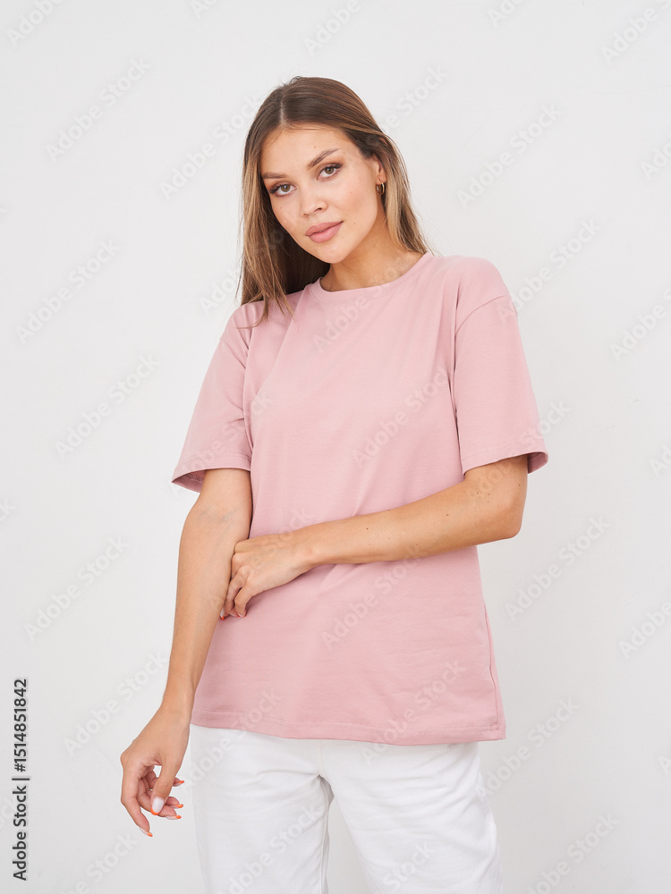 Young woman with long hair wearing plain pink short-sleeved shirt and white pants, standing in a relaxed pose with arms crossed, looking at the camera with neutral expression Young woman with long hair wearing plain pink short-sleeved shirt and white pants, standing in a relaxed pose with arms crossed, looking at the camera with neutral expression