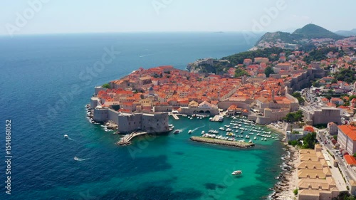 Establishing aerial shot of Dubrovnik, Croatia. Iconic old town, medieval walls, and breathtaking coastline. Beauty of the Adriatic Sea and landmark historic architecture. 4K drone wide orbit footage