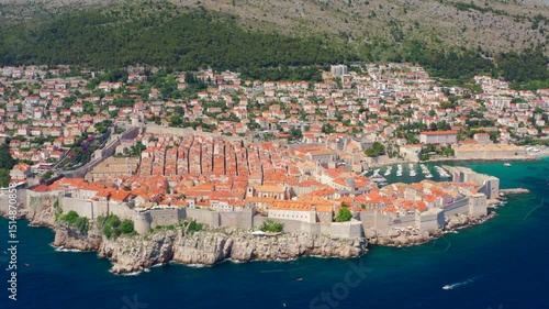 Stunning aerial footage of Dubrovnik, Croatia with historic old town, medieval walls, and breathtaking coastline. Cityscape of the Adriatic Sea and landmark architecture. 4K drone zoom out shot