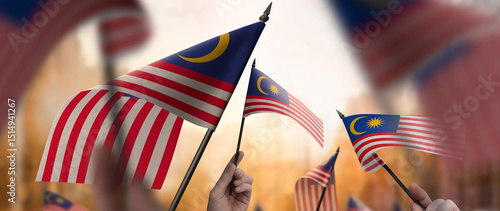 Photography Malaysia flags in their hands on a blurred urban background