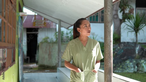 A female nurse walks slowly toward the camera in a rural outdoor setting. Captured in slow motion with natural light. Great for health, community, lifestyle, and humanitarian themes.