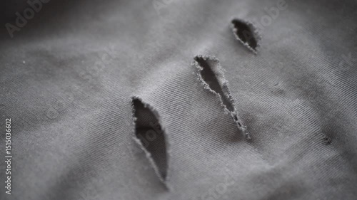 Holes in black fabric reveal wear and tear from usage