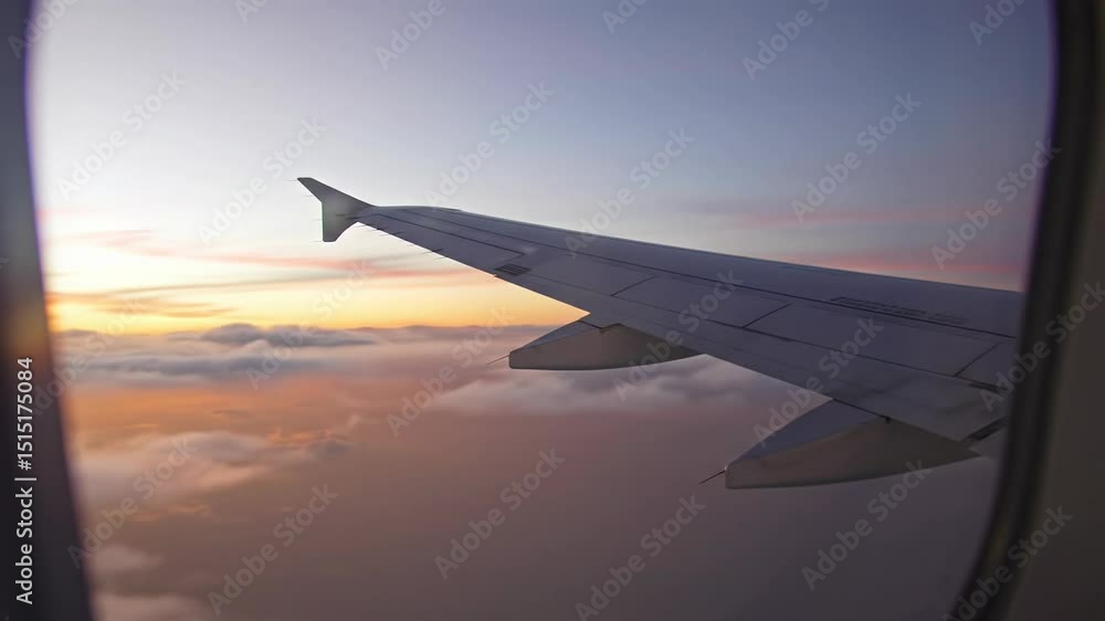 Airplane wing against a colorful sunset sky viewed from window Airplane wing against a colorful sunset sky viewed from window