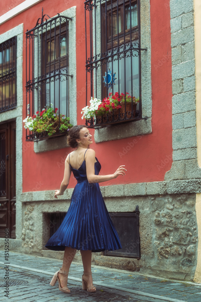 Φωτογραφία Elegant woman in blue dress twirling on charming cobblestone street