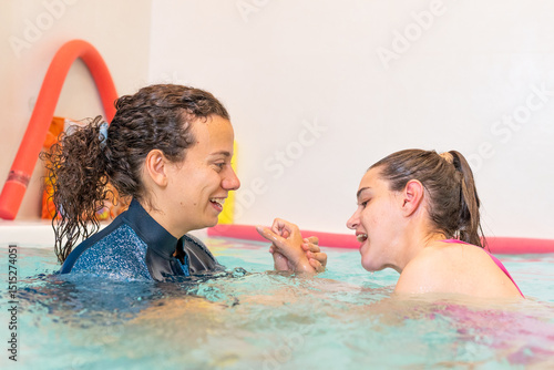 Foto Young woman with cerebral palsy in hydrotherapy session with a physiotherapist - Therapeutic aquatic exercise guided by a physiotherapist