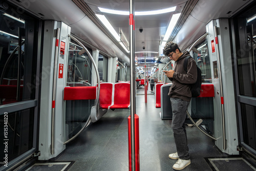 Nuremberg, Germany, August 3, 2023. A young Caucasian man checks his cell phone during the subway ride. Lifestyle on public transport.