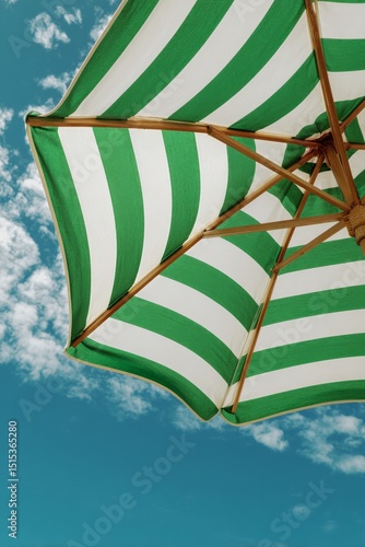 Bright Green and White Striped Beach Umbrella Against a Blue Sky With Fluffy ...