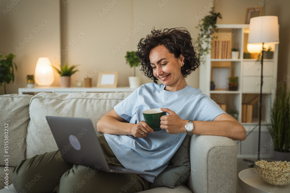 smile relax mature woman lying on sofa with cup and use laptop smile relax mature woman lying on sofa with cup and use laptop