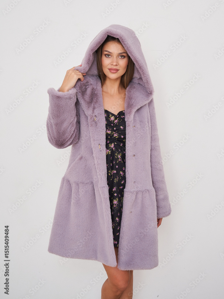 Beautiful brunette model in stylish purple coat posing cheerfully at indoor location Beautiful brunette model in stylish purple coat posing cheerfully at indoor location