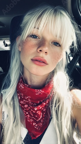 Young Woman With Long Blonde Hair and Red Bandana Taking a Selfie in a Car on...