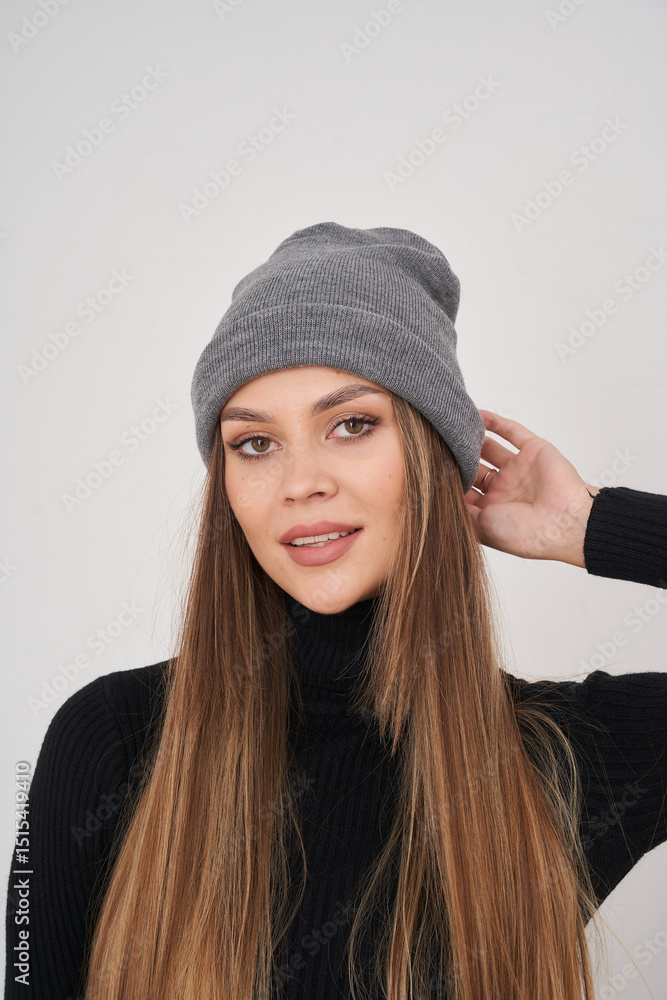 Brunette woman in a grey beanie poses cheerfully in a stylish outfit Brunette woman in a grey beanie poses cheerfully in a stylish outfit