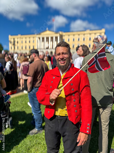 Man wearing traditional Vestfold bunad standing in front of the Royal Palace (Slottet) in Oslo, Norway. Norwegian national costume representing cultural heritage and pride.