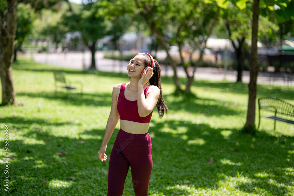 A woman is walking in a park while listening to music A woman is walking in a park while listening to music
