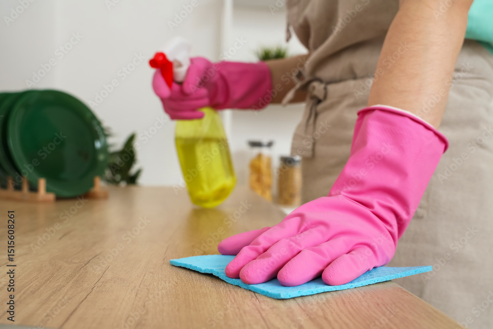 Young woman cleaning counter in kitchen, closeup Young woman cleaning counter in kitchen, closeup