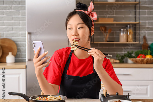 Young Asian woman with mobi...