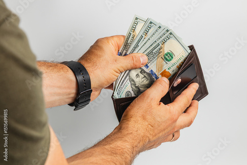 Person holds cash and wallet in hand with financial focus