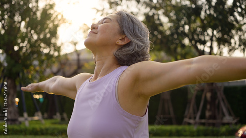 Fotografie Asia adult aged people middle age mindful happy old woman open arm yoga deep calm stress relief outdoor nature public park sun light self love relax elder aging life asian female mental health care