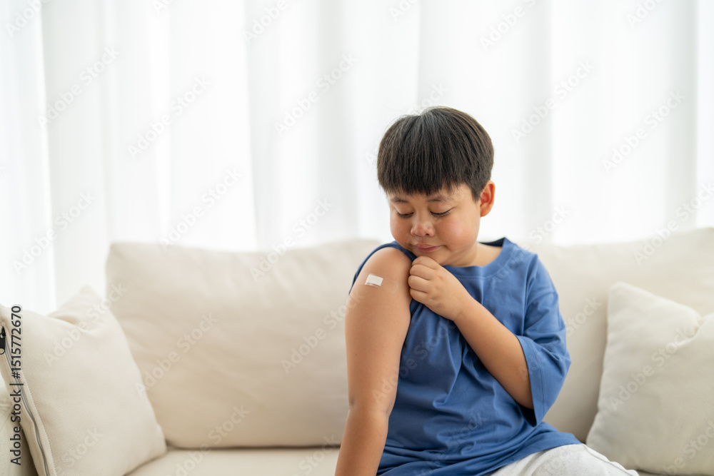Portrait of happy smile vaccinated little asian kid boy children ages 5 to 11 years old posing show arm with medical plaster after Injection vaccine Covid-19 protection.coronavirus vaccination kid Portrait of happy smile vaccinated little asian kid boy children ages 5 to 11 years old posing show arm with medical plaster after Injection vaccine Covid-19 protection.coronavirus vaccination kid