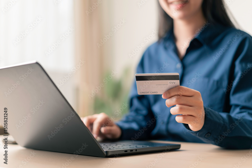 woman holding credit card in front of laptop for secure online payment and e-commerce transaction in a home office environment woman holding credit card in front of laptop for secure online payment and e-commerce transaction in a home office environment