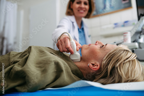 Photos Female patient undergoing thyroid ultrasound examination