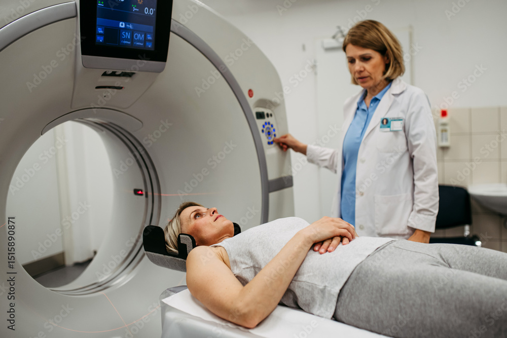Doctor operating CT machine and preparing patient for scan Doctor operating CT machine and preparing patient for scan