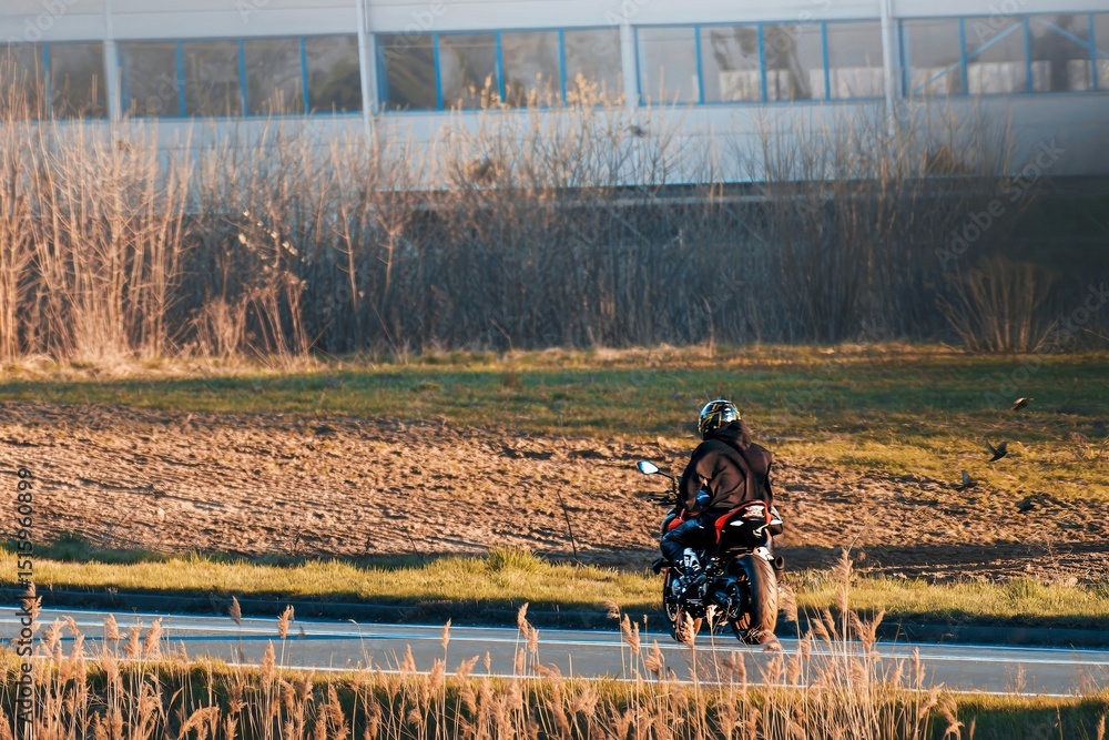 Fototapeta premium Solo biker riding fast on empty road