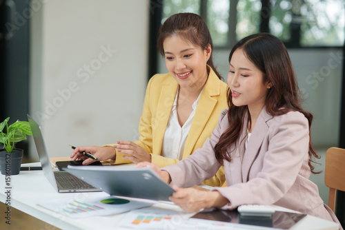 Wallpaper Mural Group of two Asian businesswomen using laptops and tablets having a meeting about working together. Torontodigital.ca