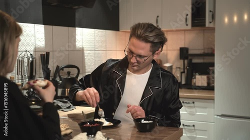 A Couple Happily Enjoying a Delicious Dessert Together in a Modern Kitchen Setting