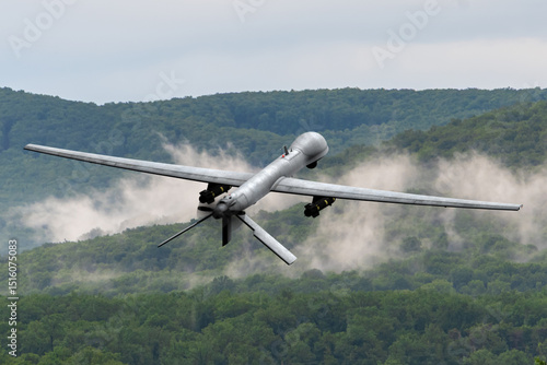 Modern technology in action - reconnaissance drone in the air. Heavy UAV with weapons in flight, filmed from behind against the background of picturesque nature.
