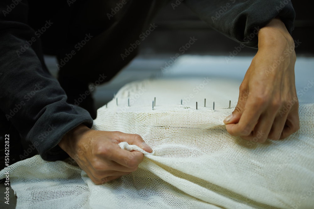 Obraz premium Part of craftswoman pulling rug embroidery base on frame