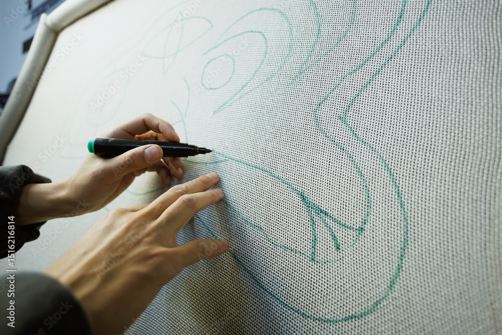 Obraz premium Part of craftswoman drawing on carpet canvas in workshop