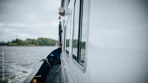 Cargo barge navigating river with mooring ropes and control panel detail