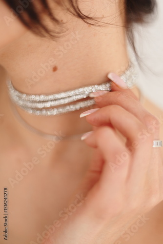 close up of a young woman holding a necklace