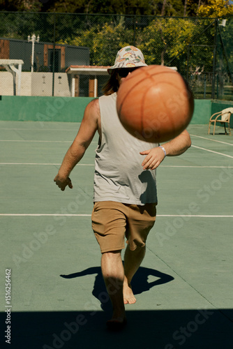 Middle-aged caucasian man playing basketball alone in the hotel of Turkey.