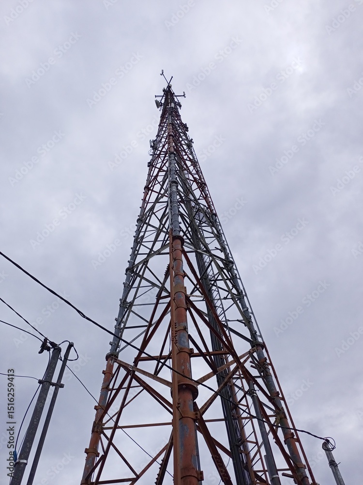 Tall Telecommunication Tower Against Cloudy Sky Tall Telecommunication Tower Against Cloudy Sky